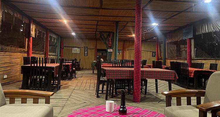 Interieur van een rustieke eetgelegenheid met tafels en stoelen.