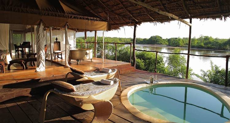 Luxurious safari lodge with a private pool and river view.
