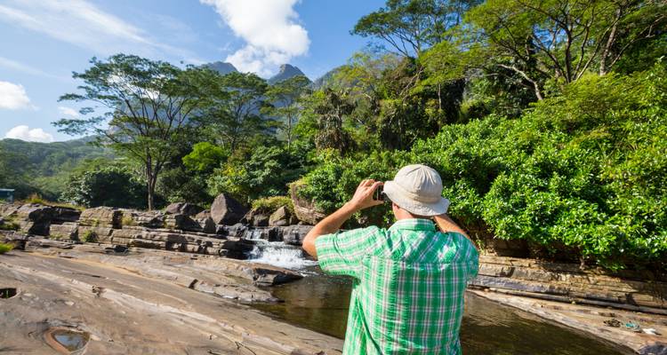 Person taking a photo of a natural stream
