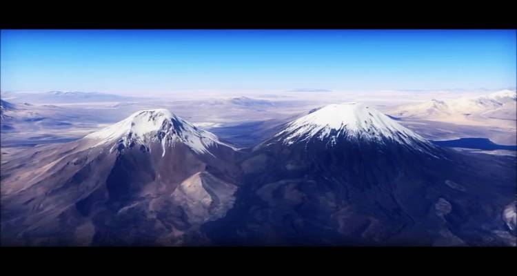 Schneebedeckte Gipfel von Zwillingsvulkanen unter einem klaren Himmel.