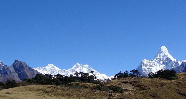 Paisaje montañoso con varios picos blancos distintivos contra un cielo azul.