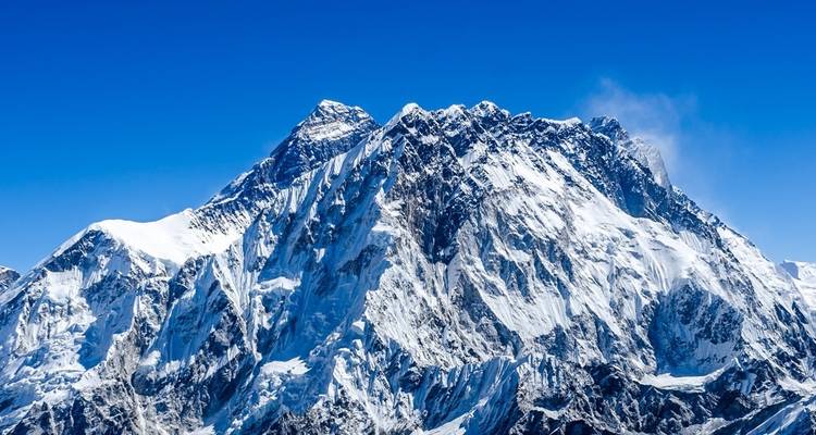 Un pico montañoso escarpado y majestuoso cubierto de nieve.