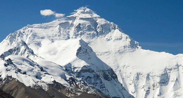Una montaña prominente cubierta de nieve bajo un cielo azul despejado.