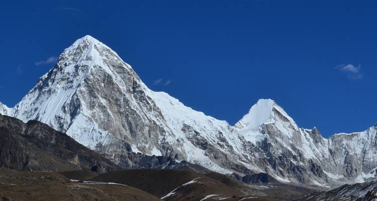 Un pico nevado con un fondo de cielo azul profundo.