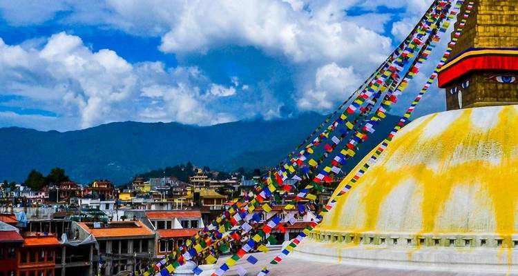 Stupa met vlaggen en stedelijk landschap op de achtergrond.