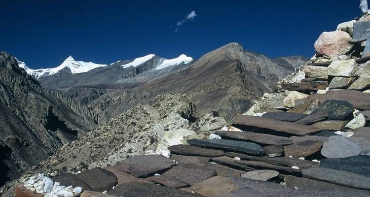 Hochgebirgsweg gesäumt von eingemeißelten Steinplatten.
