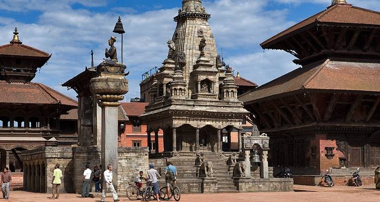 Des gens et des cyclistes autour des temples de Bhaktapur Durbar Square.