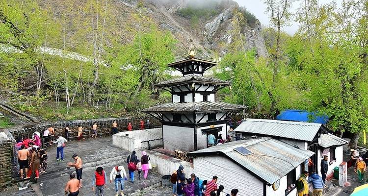 Tempel mit Menschen drum herum und üppigen Hügeln