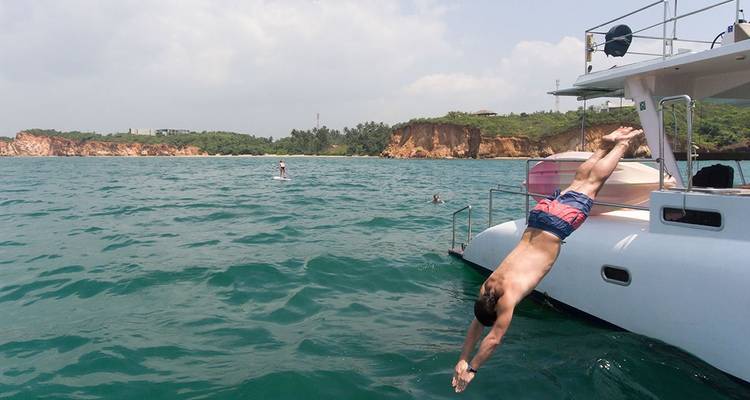 Man die vanaf een boot in de oceaan duikt.