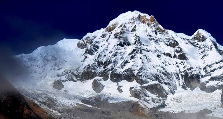 Schneebedeckte Bergkette unter einem tiefblauen Himmel.