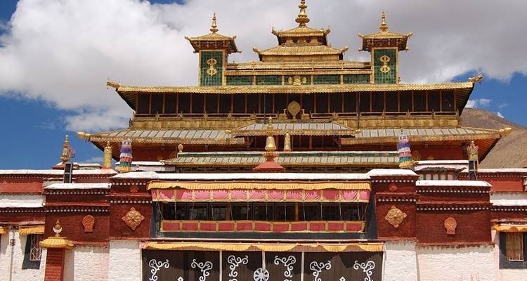 Red and gold Tibetan temple with intricate architecture.