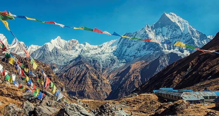 Colorful prayer flags in front of a mountain range.