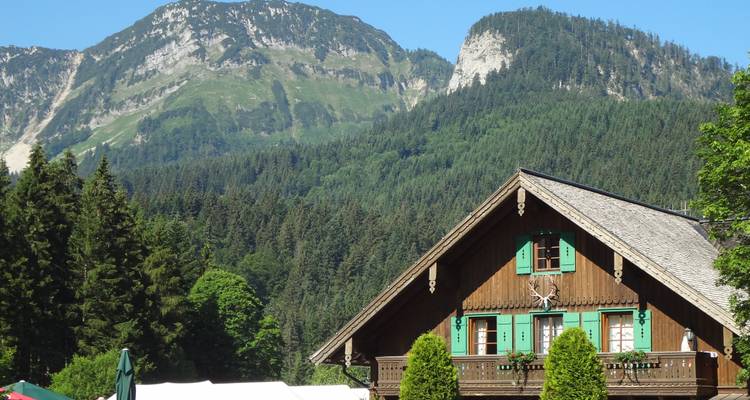 Casa tradicional de madera con montañas de fondo.