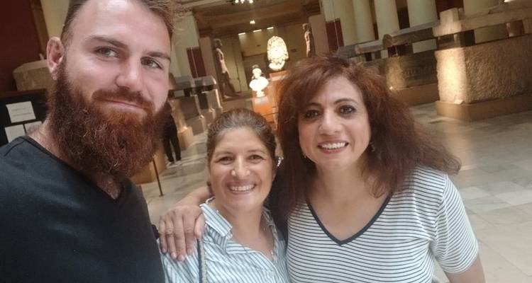 Group selfie inside a museum with statues in the background.