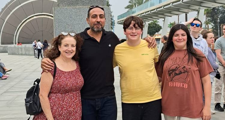 Family posing in front of a modern architectural structure.