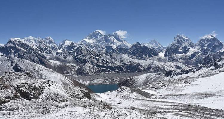 Vista panorámica of cadena montañosa cubierta de nieve y lago.
