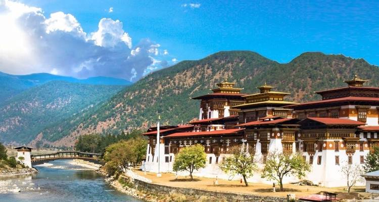Punakha Dzong by the river with mountains in the background.