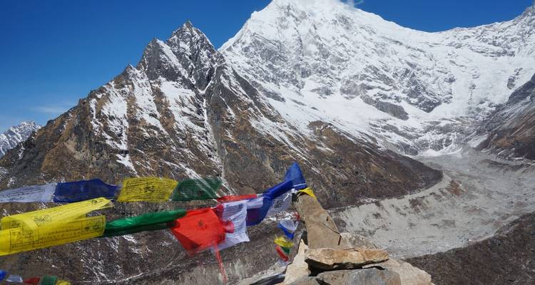Snow-capped mountains with prayer flags in the foreground.