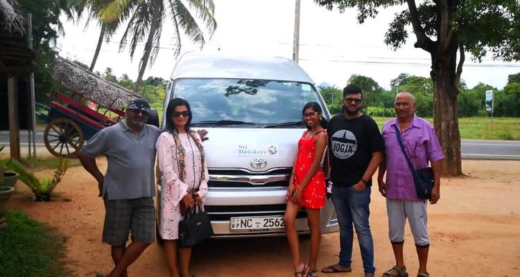 Group of people posing in front of a van.