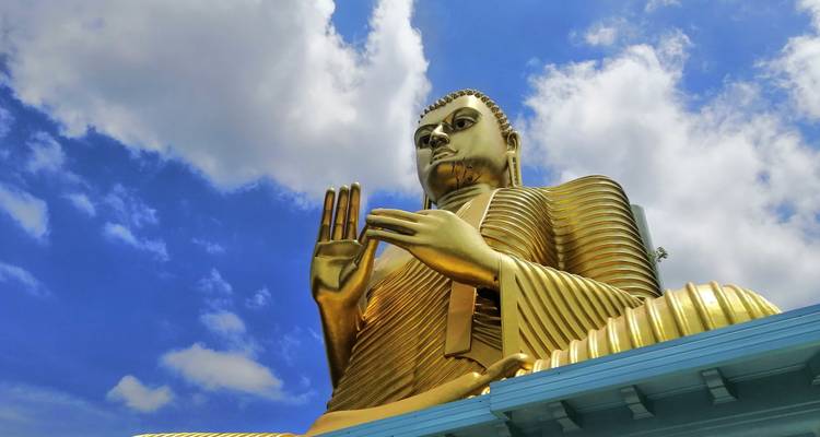 Golden Buddha statue reaching towards the sky.