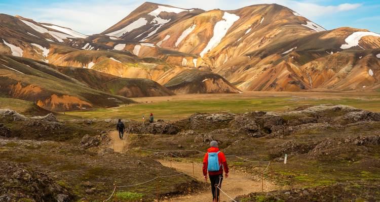 Varios excursionistas siguen un sendero con cuerdas hacia el colorido valle de Landmannalaugar.