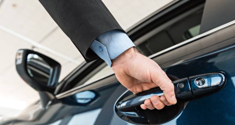 Een hand die een autoportier opent, met een close-up opname.