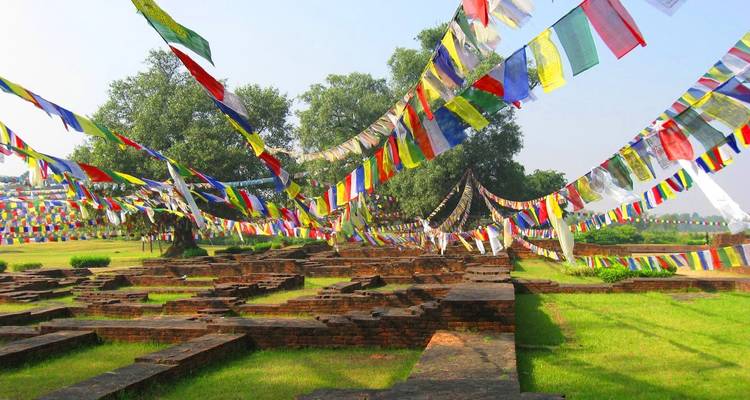 Historic ruins covered with colorful prayer flags on a sunny day.