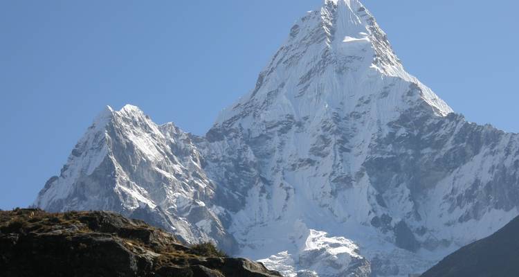 Snow-capped mountain peak under clear blue sky.