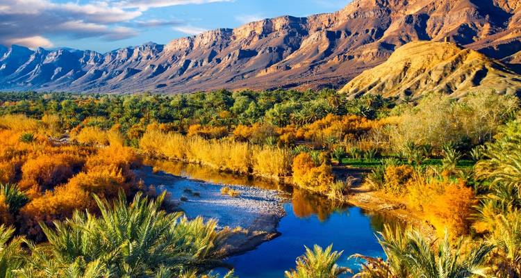 Expansive view of a river acting as a natural boundary with impressive mountains.