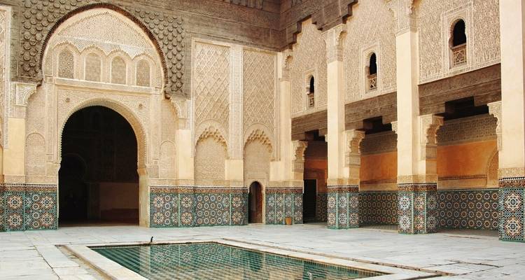 Aufwendige architektonische Details und ein Pool in einem historischen marokkanischen Innenhof.