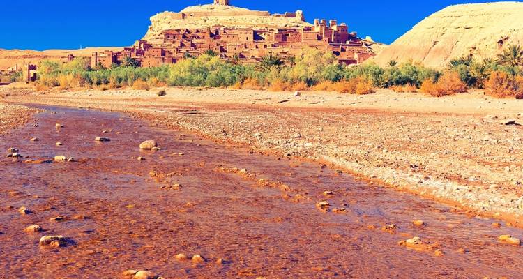 Ait Benhaddou mit üppiger Vegetation in einer Wüstenlandschaft.