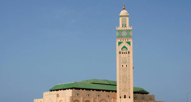 Eine Moschee mit einem hohen Minarett unter einem klaren blauen Himmel.
