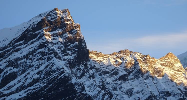 Falaise de montagne enneigée avec lumière dorée du soleil