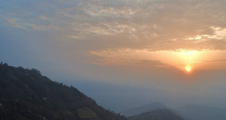 Berglandschaft bei Sonnenuntergang mit klarem Himmel und fernen Gipfeln.