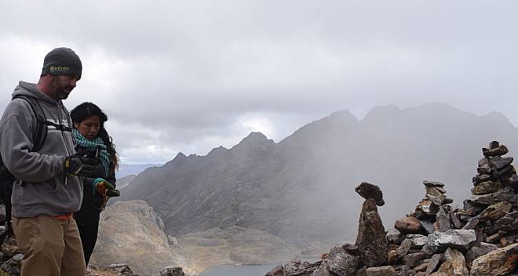Two people with backpacks on a mountainous trail.