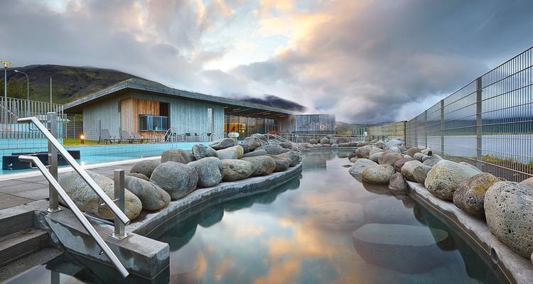 Geothermal spa with enclosed hot spring and mountainous view.