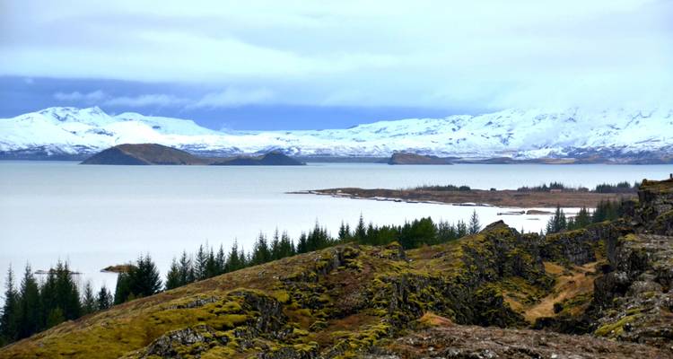 Calm lake with snowy mountains in the distance.
