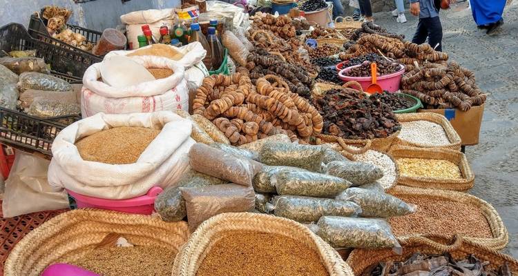 Variété de sachets d'épices et de produits séchés dans un environnement de marché.