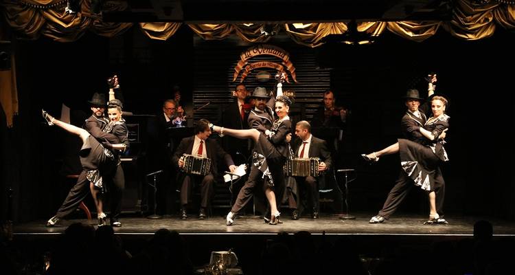 Tango performance with dancers and musicians on stage.