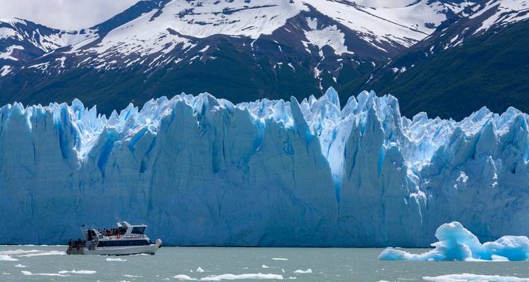 Large glacier with a boat in the foreground.
