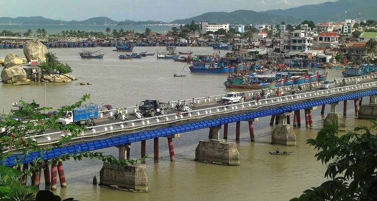 Brücke über einen Fluss mit Booten und Stadtblick.