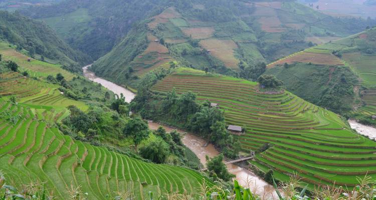 Green terraced hills and a winding river in a rural setting.