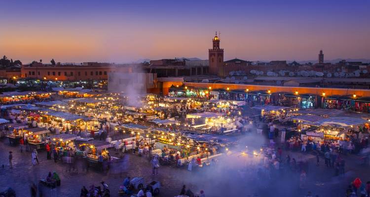 Geschäftiger Nachtmarkt mit bunten Lichtern.
