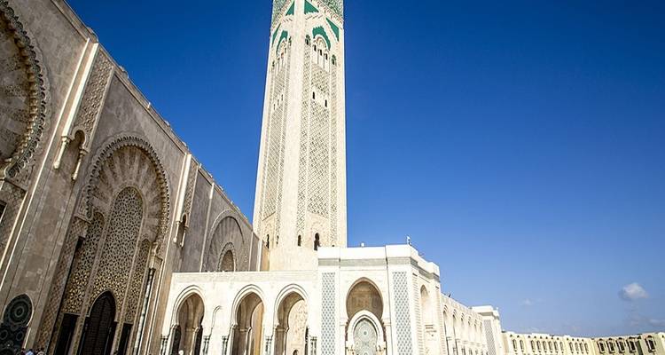 Mosquée Hassan II avec son minaret élancé contre un ciel bleu.