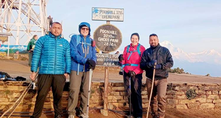 Gruppe posiert mit Poon Hill Schild und Bergblick