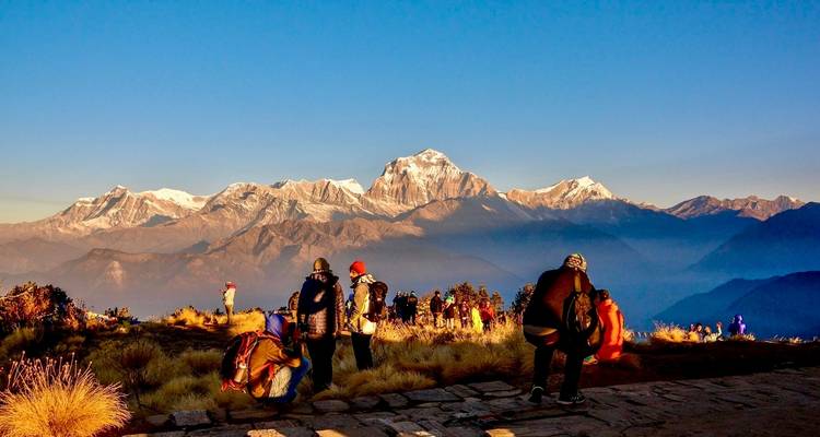 Personengruppen, die in der Morgensonne den Bergblick genießen