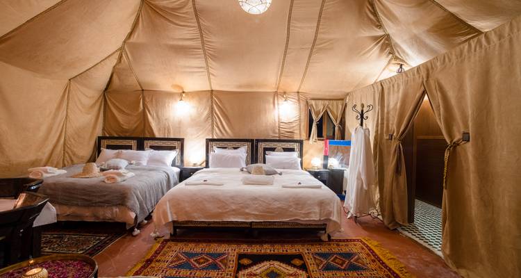 Interior de una tienda del desierto con camas y decoración tradicional.