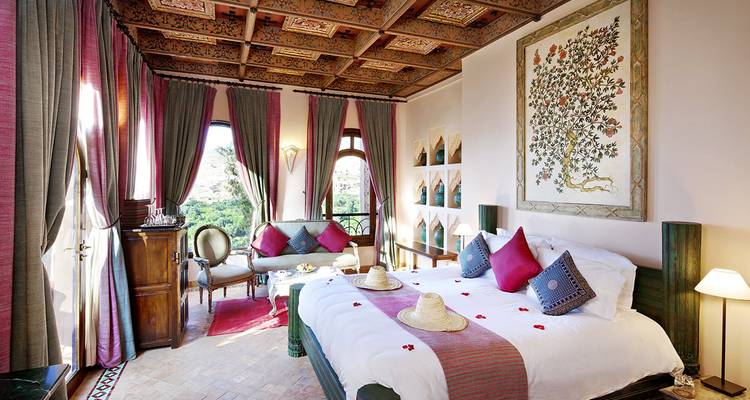 Lujosa habitación de hotel con decoración rica y elementos tradicionales.