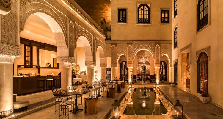 Luxueus restaurant interieur met sfeerverlichting en bogen.