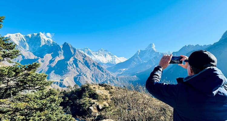 Person taking a photo of mountain range with a phone.